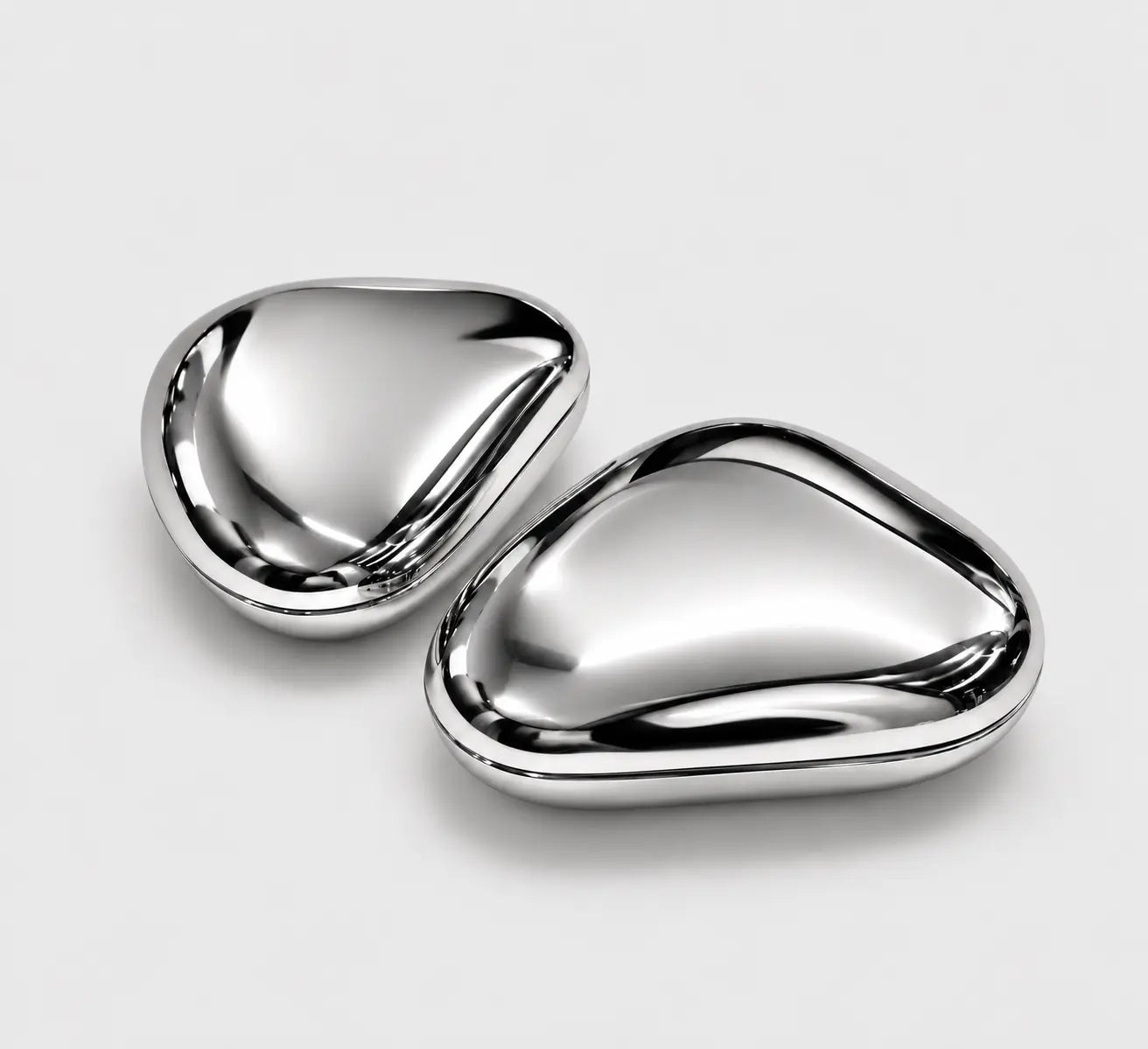 Two closed Skinsei Labs chrome compacts arranged at an angle